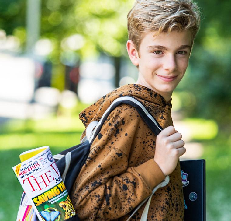 Boy wearing a backpack looking at camera